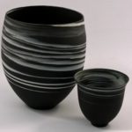 Large and small white on black agateware beakers