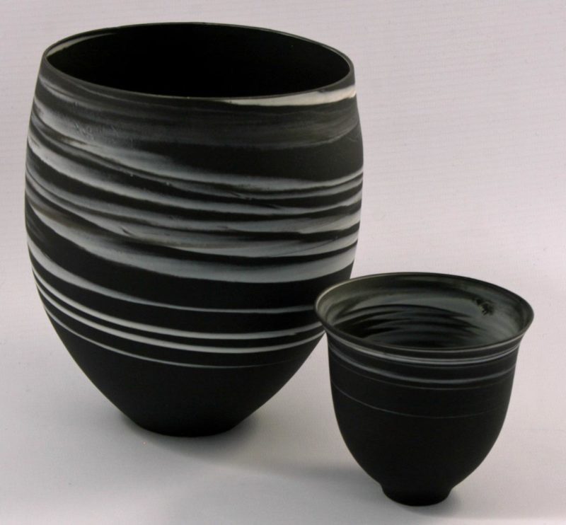 Large and small white on black agateware beakers